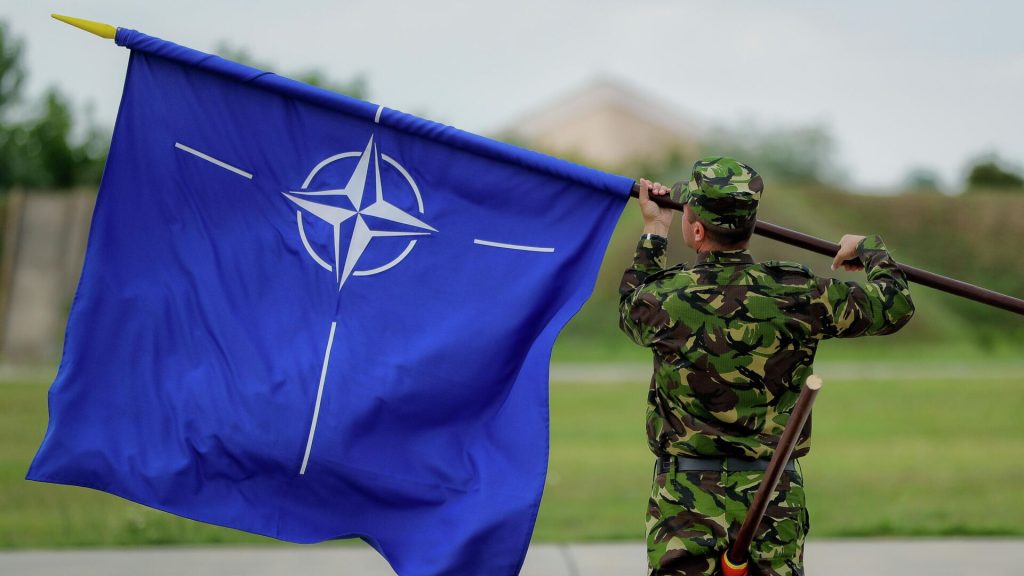 Военнослужащий с флагом НАТО на авиабазе в Румынии